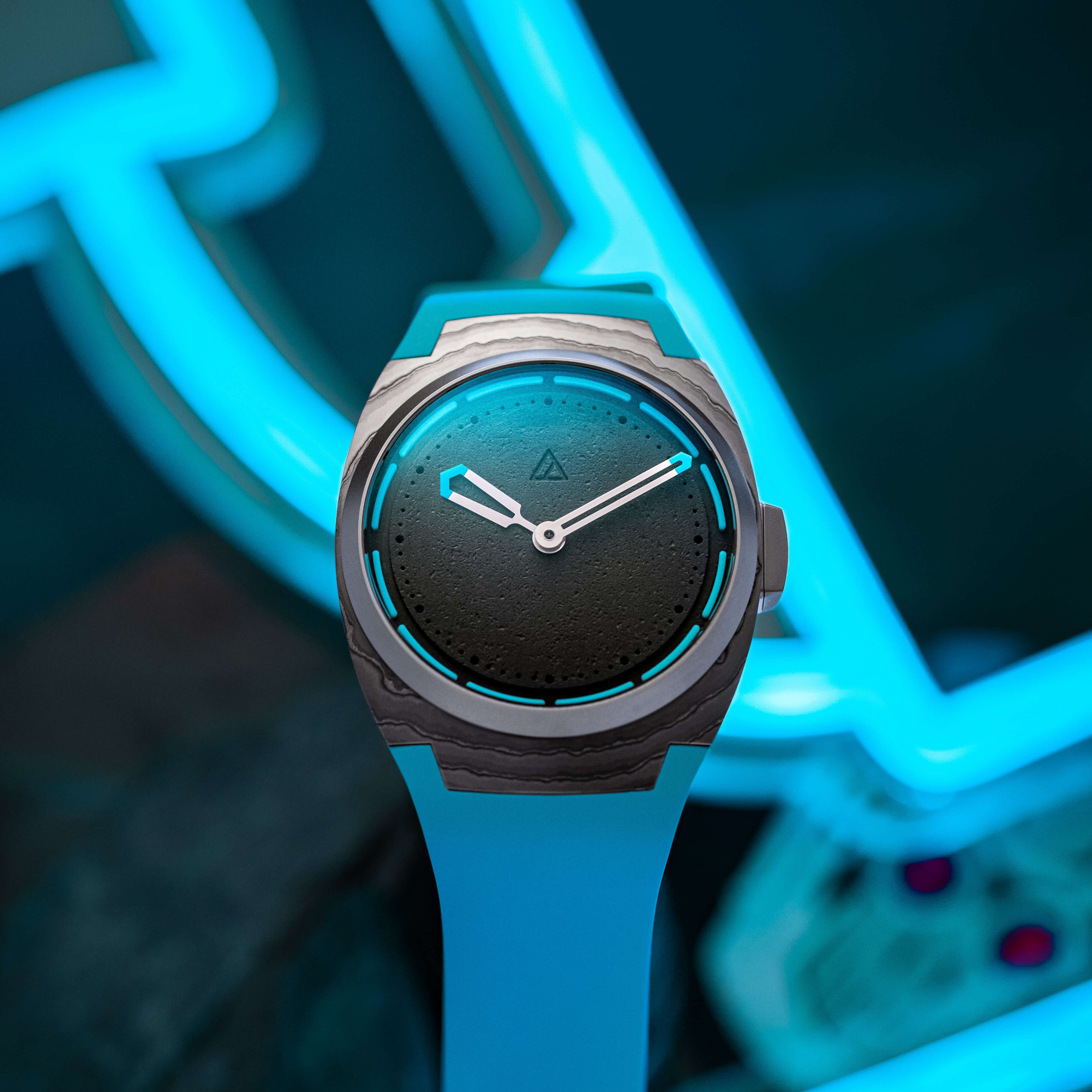 Wristwatch with a black face and blue accents on a white strap, set against a neon blue background.