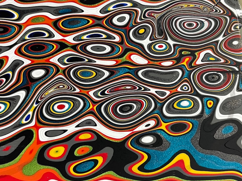 A cross-section of classic Fordite, showing many colours of the rainbow.